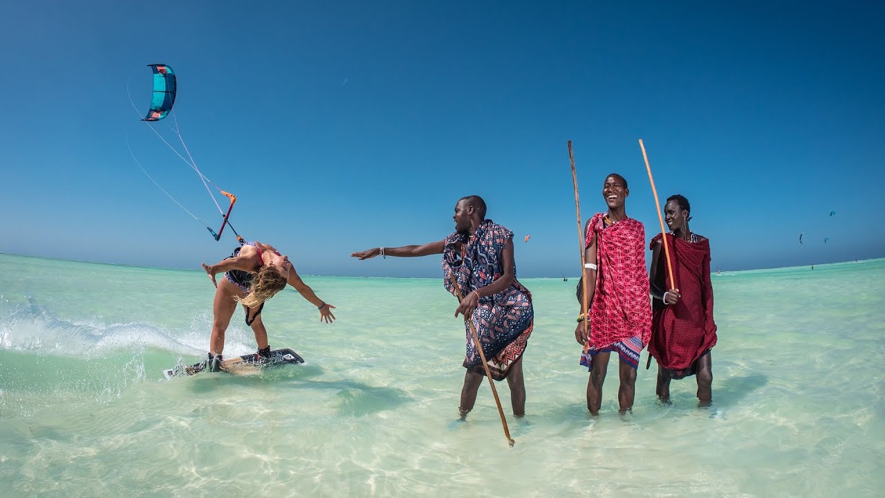 Woman kitesurfing locals watching her, enjoy it!